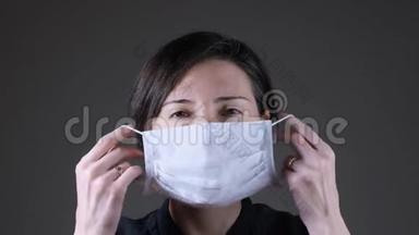 一名白人妇女戴着并摘下白色医疗面具的肖像。 预防传染病、冠状病毒